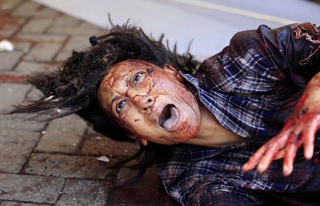 An injured woman cries for help. (Photo by Noor Khamis/Reuters) 